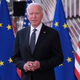 Joe Biden standing in front of American and European Union flags